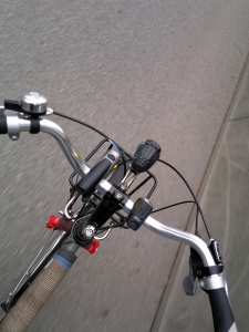 View down to bicycle handle bars and street Gray, drab